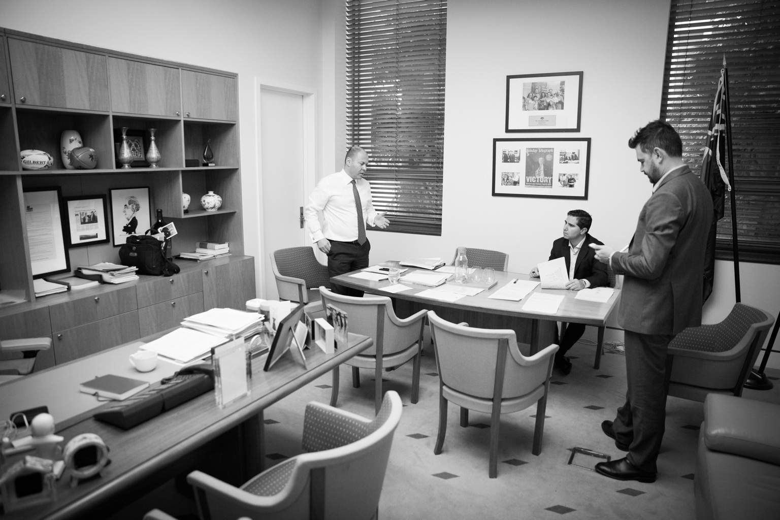Kane Silom standing beside a meeting table during an office discussion
